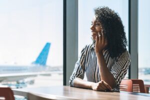 woman-mobile-phone-waiting-her-flight-airport_